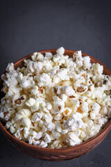 Salted popcorn in a bowl with 3D glasses on a table on a gray background. Top view