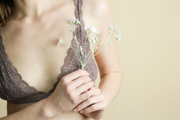 Female in lace bra holding flower. Prevention of breast diseases, woman health and self care...