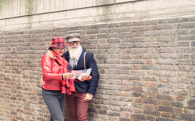 Senior couple with map and city guide on street. Pensioner reading tourist map London.  Love and joyful elderly lifestyle concept.