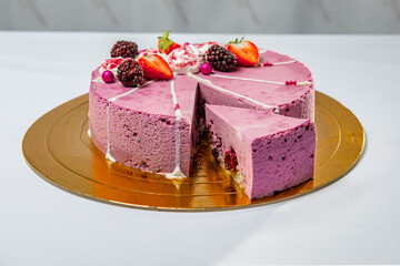 Round berry cake with berry filling and strawberries and blackberries on top