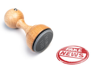 round FAKE NEWS rubber stamp and red imprint on white background