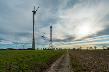 Wind turbines in the field on a dirt road