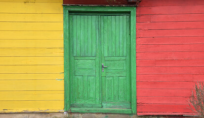 An old, colorful wooden house with a colorful door in the middle