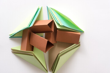 folded green blue and brown paper squares with triangular brown paper objects