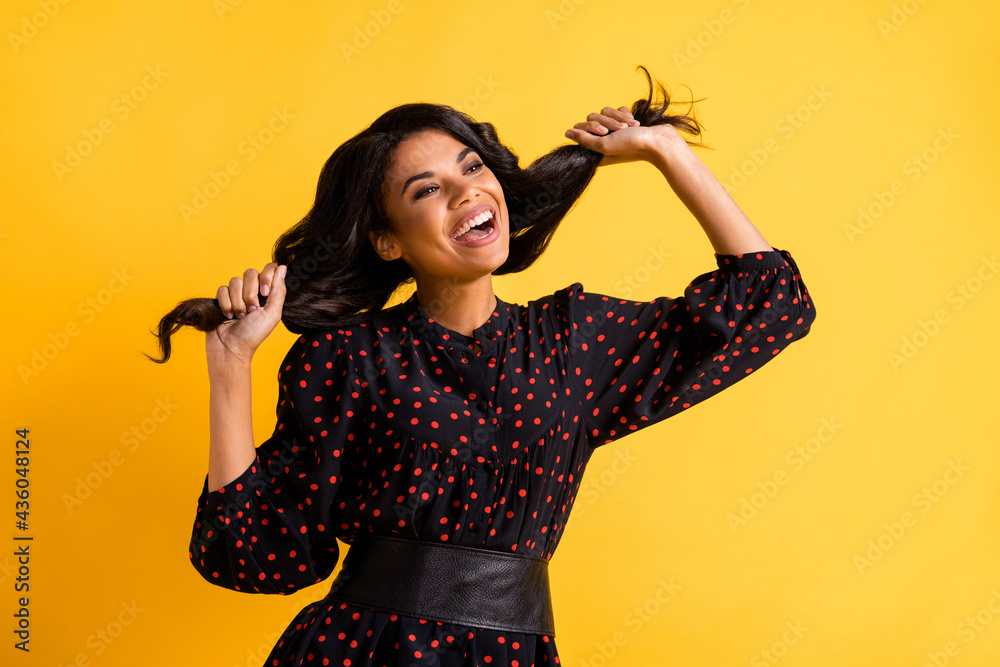 Sticker photo of young happy excited smiling afro girl hold tails look copyspace dancing isolated on yellow 