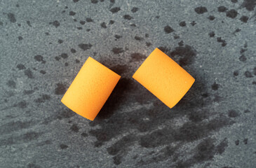 Two new orange foam earplugs top view