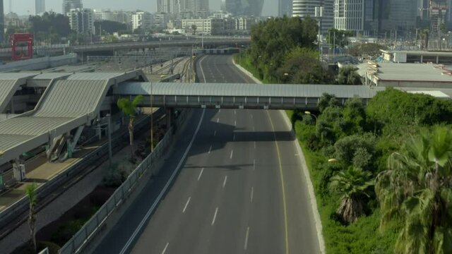 Aerial Shot Of Road By Railway Station In City During Pandemic, Drone Flying Over Highway On Sunny Day - Tel Aviv, Israel