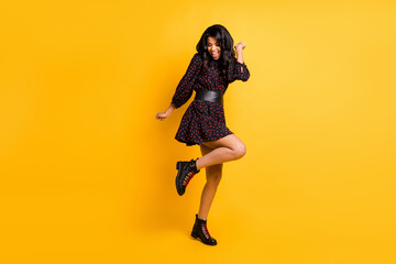 Fototapeta na wymiar Full body photo of pretty excited dark skin person raise knee have good mood isolated on yellow color background