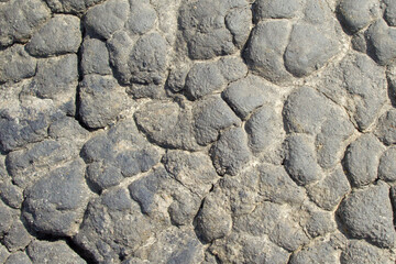 Dried gray black clay surface covered with cracks. The surface is in the form of clay build-up. Copy space, top view, textured, background.