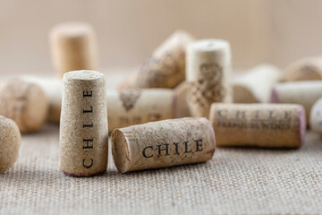 Close up macro of few vertically positioned wine corks with sign Chile on canvas fabric. Wine...