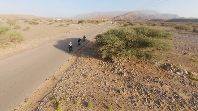Three People practicing their Hobby which is cycling in the street in alSharqiyah, Oman.