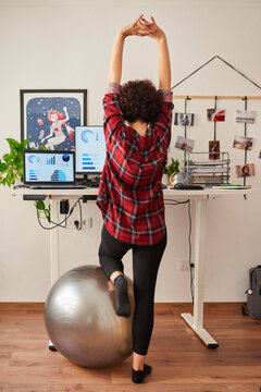 Woman telecommuting at an adjustable standing desk