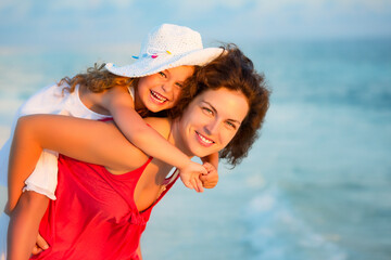 Portrait of happy mother and little daughter on sunny beach on Maldives at summer vacation. Family on the beach concept.