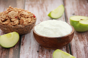 white milk yogurt in a cup and muesli in a plate