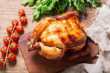 whole roasted chicken on a wooden board, top view