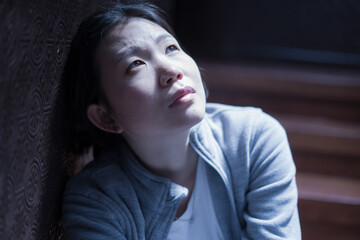 young beautiful Asian woman in pain suffering depression - dramatic indoors portrait on staircase of sad and depressed Korean girl as victim of bullying and abuse