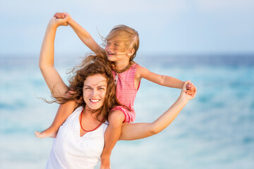 Happy mother and little daughter having fun on beach on Maldives at summer vacation. Family on the...