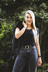 Vertical shot of a blonde Hispanic female posing in a park