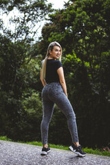 Vertical shot of a blonde Hispanic female posing in a park