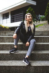 Vertical shot of a blonde Hispanic female sitting in a park