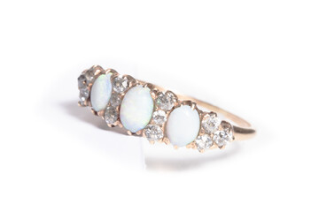 A diamond and opal ring on white