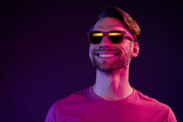 Portrait of attractive cheerful successful dreamy guy wearing specs isolated over dark neon purple color background