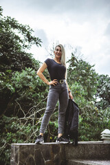 Vertical shot of a blonde Hispanic female posing in a park