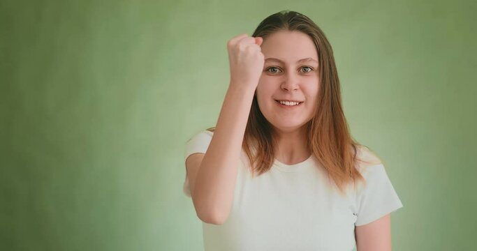 Lady in white t-shirt threatens by fist and finger on green