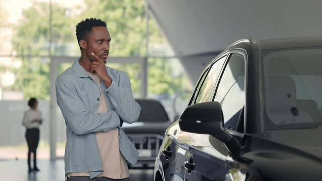 African american man choosing car at modenr salon