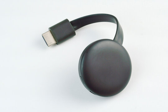 Chromecast media streaming player device on white background. Selective focus. Top view.