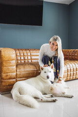 Blonde female stroking her white swiss shepherd and Maltese dog