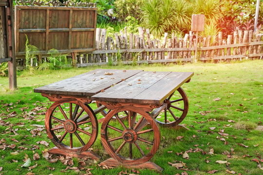 wooden cart table with 4 wooden wheels in garden. Old fashioned cart.