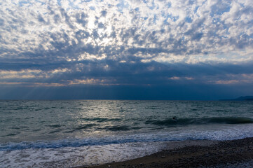 sea landscape is a pebbly beach with waves in white foam