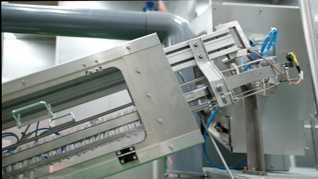 Conveying preforms to form water bottles in an automatic blow molding machine to produce drinking water.