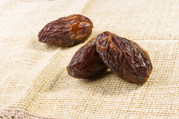 Big luxury dried date fruit on a linen napkin, kurma ramadan kareem concept, close up.