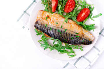 Roasted mackerel served with arugula and tomatoes. Fish meal. Top view