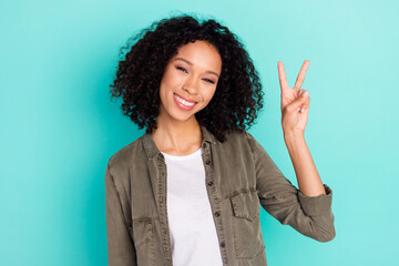 Portrait of attractive cheerful wavy-haired girl showing v-sign spring good mood isolated over bright blue color background