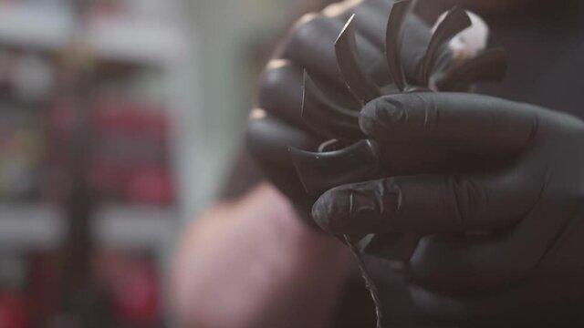 Close hands in black gloves shoot of electronic technic repairer cleaning cooler detail. He uses a napkin to remove dust cooling fan blades