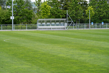 Fresh mowed empty football field with covered bench at springtime. Photo taken May 27th, 2021,...