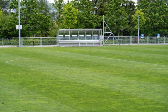 Fresh mowed empty football field with covered bench at springtime. Photo taken May 27th, 2021, Zurich, Switzerland.