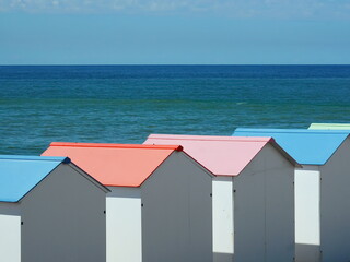 White cabanas with pastel roofs on the coast of Le Treport, France