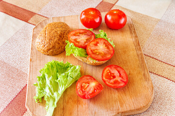 Bun with lettuce and chopped tomato. A healthy breakfast.