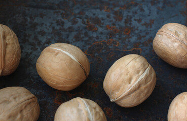 whole round walnuts in the skin on a metal background