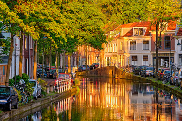 Obraz premium Delt canal with old houses and cars parked along on sunset