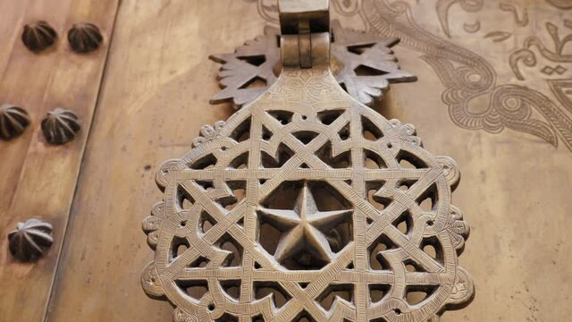 Iron brass door handle knocker in a traditional Moroccan islamic geometric shape design. Intricate handmade metalwork.