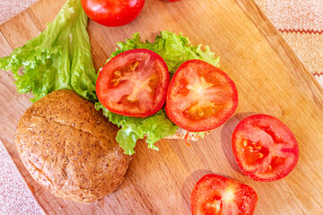 Bun with lettuce and chopped tomato. A healthy breakfast.