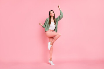Fototapeta na wymiar Full body charming victorious young woman raise fists smile winner isolated on pastel pink color background