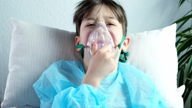 little patient in shirt, child, boy lies, facial oxygen mask, concept of medical care, anesthesiology and intensive care, oxygen therapy, treatment of coronavirus, COVID-19