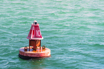 Close up  of a red channel marker buoy along a navigable channel to a harbour