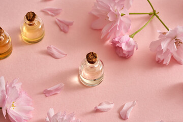 Bottles of essential oil with kwanzan cherry flowers in spring